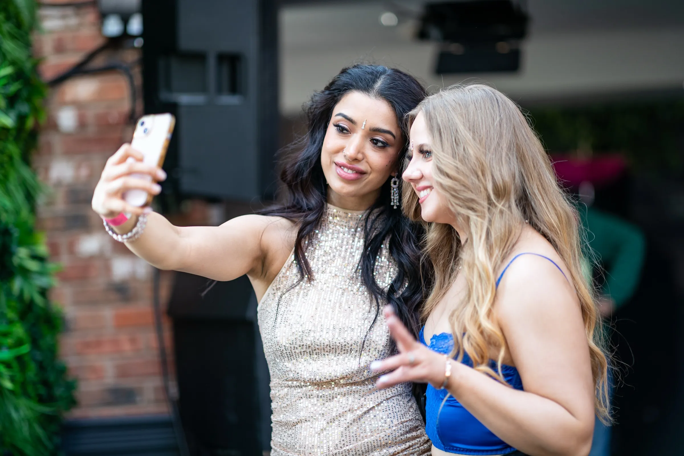 Two guests taking a selfie together at a Bollywood brunch event